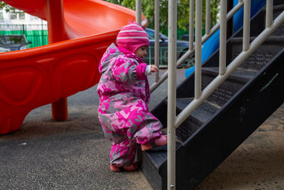 Full length of boy climbing on steps at park