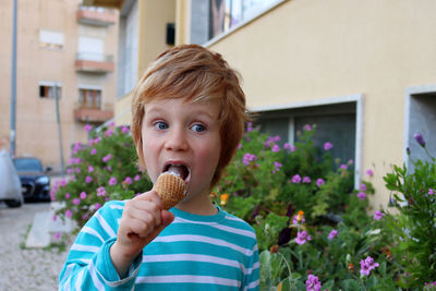 The blond boy eats ice cream and looks playfully into the distance.five year old boy with ice cream.