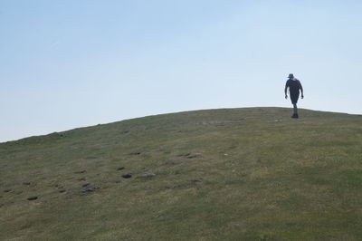 Man on landscape against clear sky