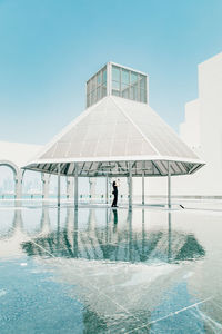 Man standing by swimming pool against sky