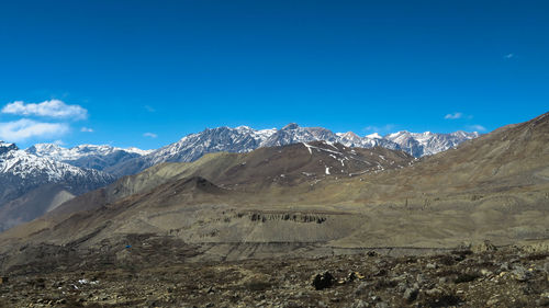 Scenic view of snowcapped mountains against blue sky