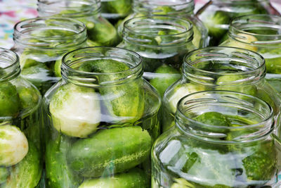 Close-up of cucumbers in jars for sale at market stall