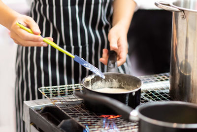 Midsection of man preparing food in kitchen