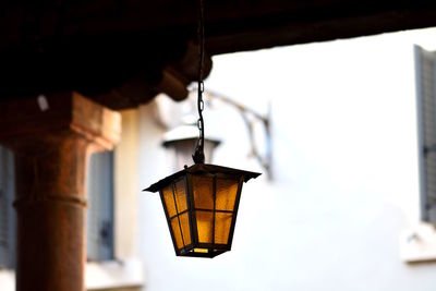 Low angle view of illuminated pendant light hanging on ceiling