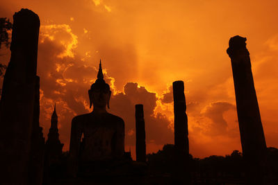 Silhouette statue against sky during sunset