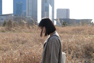 Side view of young woman standing on field