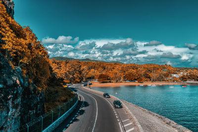 Road by trees against sky