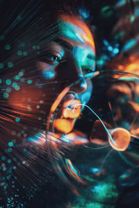 Digital composite image of woman and plasma ball with fiber optics