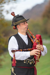 Mature man playing bagpiper outdoors