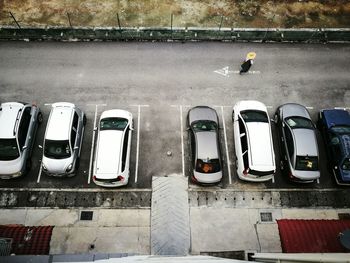 High angle view of person walking on road by cars