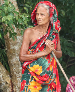 Mid adult woman standing against plants