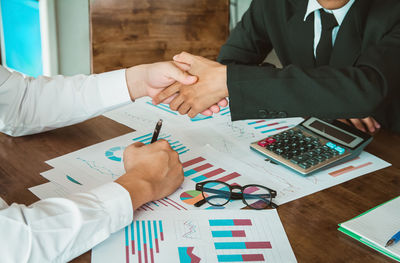 Midsection of business colleagues working on table