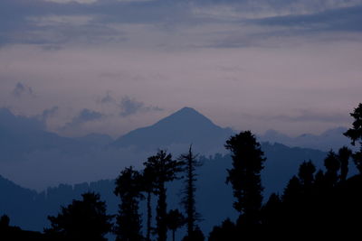 Silhouette trees on landscape against sky