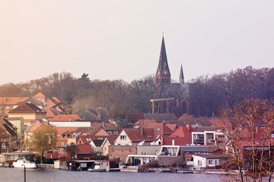 Residential buildings and church against clear sky