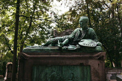 Low angle view of statue against trees