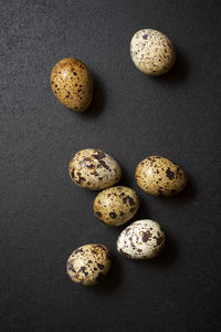 Quail eggs on a black table.
