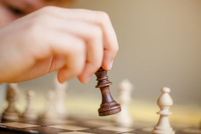 Cropped hand of boy playing chess