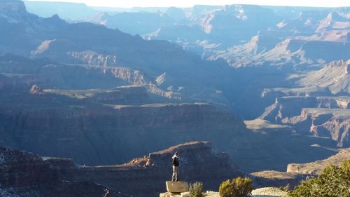 Rear view of a man overlooking rocky landscape