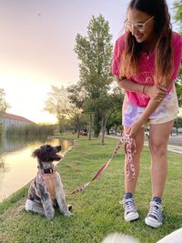 Side view of woman with dog on field