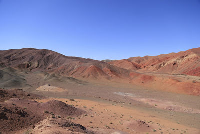 Scenic view of desert against clear blue sky