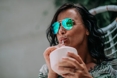 Close-up portrait of a young woman drinking drink