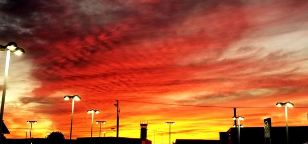 Low angle view of illuminated street light against dramatic sky