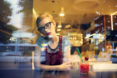 Woman sitting by window at restaurant