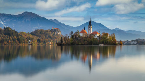 Scenic view of lake by buildings against sky