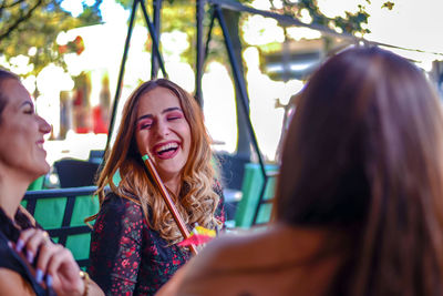 Close-up of smiling young woman sitting outdoors