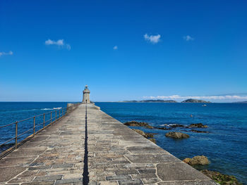 Pier over sea against blue sky