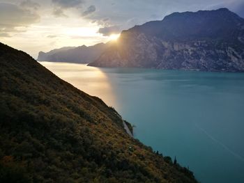 Scenic view of sea and mountains against sky during sunset