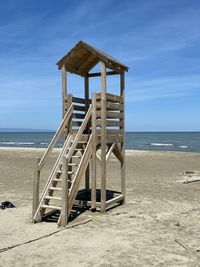 Lifeguard hut on beach against sky