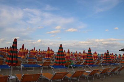 Panoramic view of chairs on beach against sky