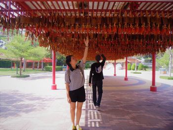 Full length of visitors touching prayer blocks at temple