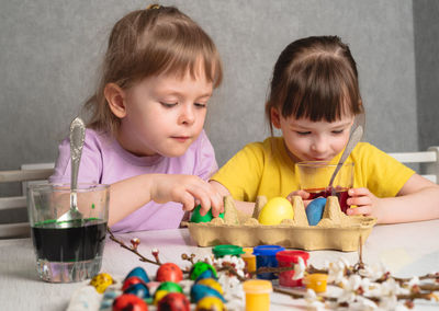 Children coloring easter eggs with paints. preparing for a happy easter holiday