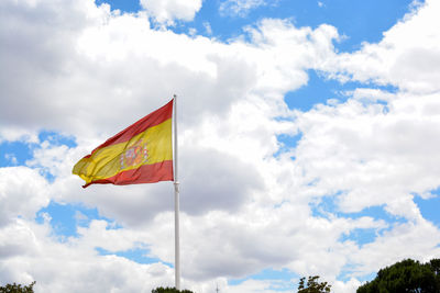 Low angle view of flag against cloudy sky