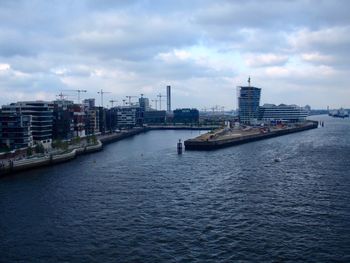 Scenic view of river by buildings against sky