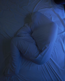 High angle view of person sleeping on bed