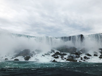 Scenic view of waterfall against sky