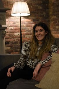 Portrait of smiling young woman sitting on sofa at home