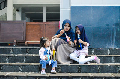 Rear view of people sitting on staircase