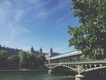 Arch bridge over river against buildings