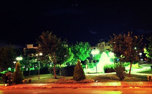 Illuminated street light against sky at night