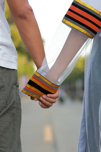 Midsection of couple holding hands outdoors