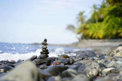 Stack of stones on beach against sky