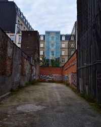 Cobblestone street in city against sky