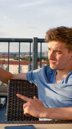 Close-up of man using mobile phone against sky