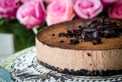 Close-up of chocolate cake by pink roses