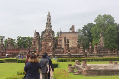 Rear view of people outside temple against building