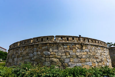 Stone wall against clear blue sky